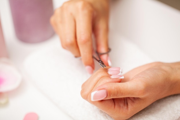 Mulher bonita feliz fazendo manicure ao descansar em casa