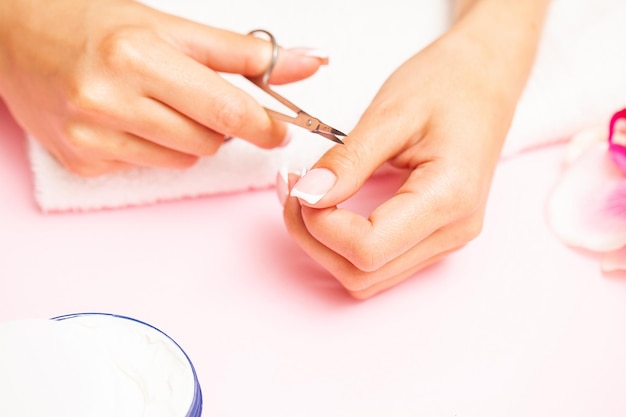 Mulher bonita feliz fazendo manicure ao descansar em casa