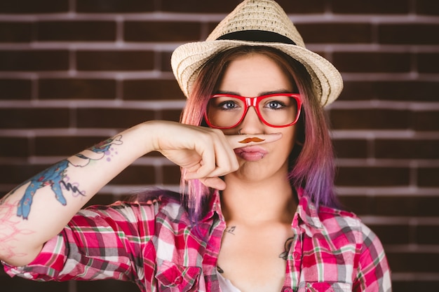 Foto mulher bonita, fingindo ter um bigode falso