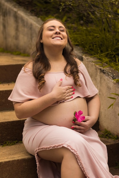 Foto mulher bonita grávida sentada em degraus