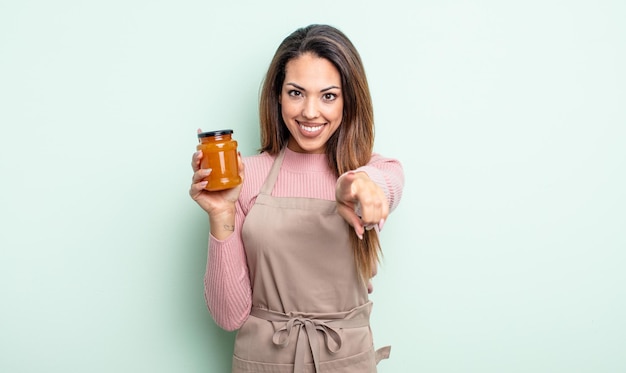 Mulher bonita hispânica apontando para a câmera escolhendo você. conceito de geléia de pêssego