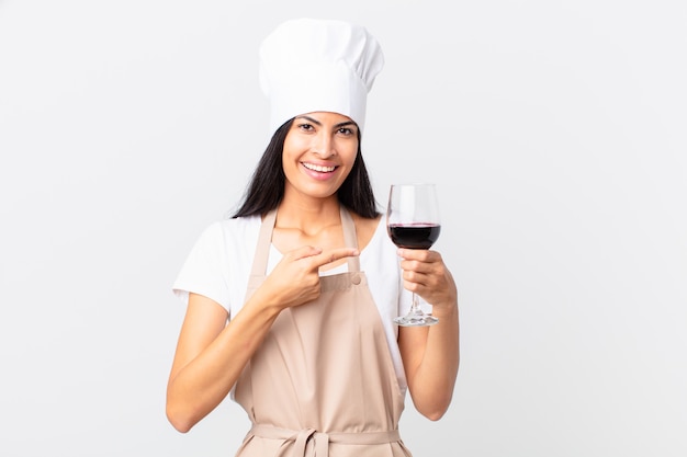 Mulher bonita hispânica chef segurando uma taça de vinho