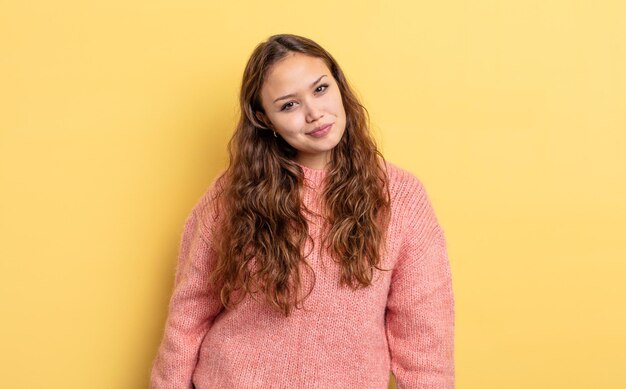 Mulher bonita hispânica com aparência de orgulhosa, confiante, descolada, atrevida e arrogante, sorrindo e se sentindo bem-sucedida