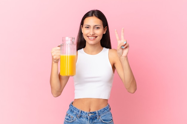 Mulher bonita hispânica com suco de laranja. conceito de café da manhã