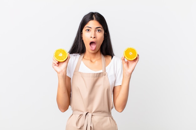 Mulher bonita hispânica do chef. suco de laranja e conceito de café da manhã