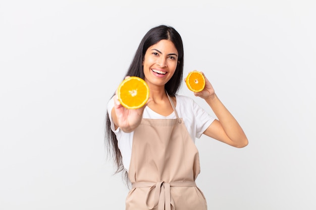 Mulher bonita hispânica do chef. suco de laranja e conceito de café da manhã