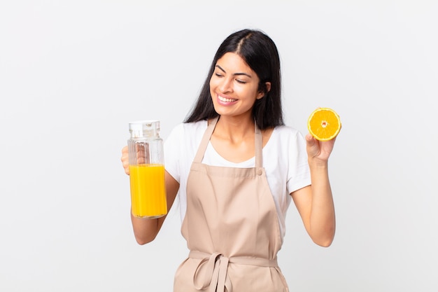 Mulher bonita hispânica do chef. suco de laranja e conceito de café da manhã