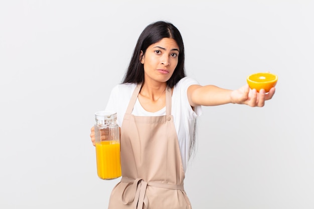 Mulher bonita hispânica do chef. suco de laranja e conceito de café da manhã