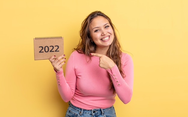 Mulher bonita hispânica olhando animada e surpresa apontando para o lado. conceito de calendário