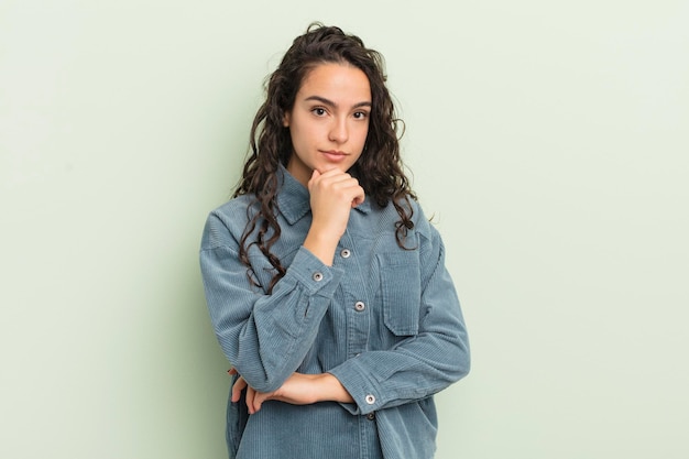 Foto mulher bonita hispânica olhando séria, confusa, incerta e pensativa, duvidando entre opções ou escolhas