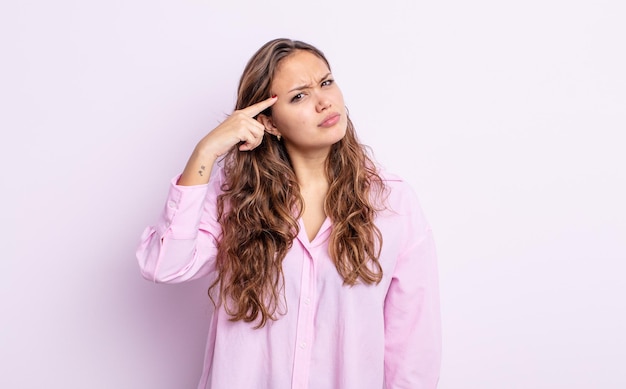 Mulher bonita hispânica se sentindo confusa e perplexa, mostrando que você é louco, louco ou louco