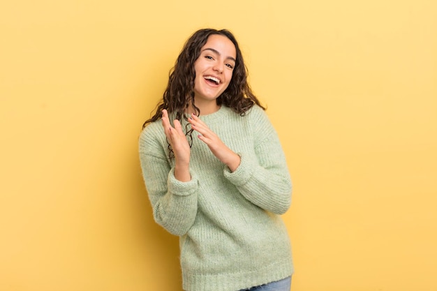 mulher bonita hispânica se sentindo feliz e bem-sucedida, sorrindo e batendo palmas, dizendo parabéns com aplausos