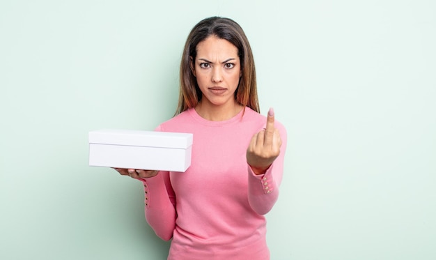 Mulher bonita hispânica se sentindo irritada, irritada, rebelde e agressiva. conceito de embalagem caixa branca