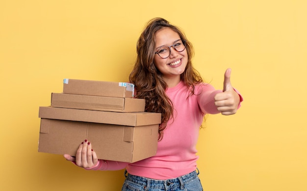 Mulher bonita hispânica se sentindo orgulhosa, sorrindo positivamente com o polegar para cima. conceito de armazenamento