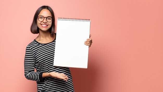 Mulher bonita hispânica segurando um caderno de desenho