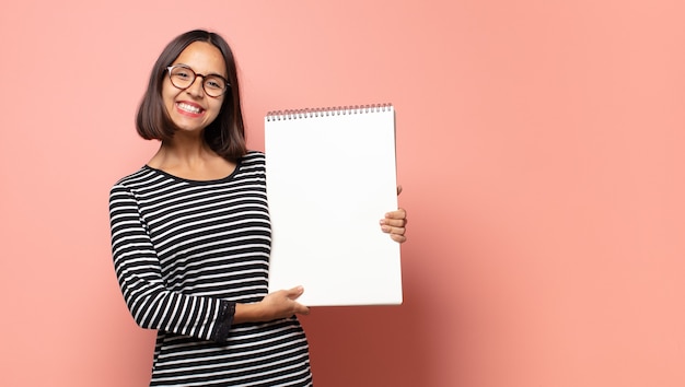 Mulher bonita hispânica segurando um caderno de desenho