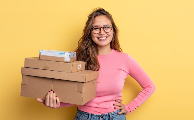 Mulher bonita hispânica, sorrindo alegremente com uma mão no quadril e confiante. conceito de armazenamento