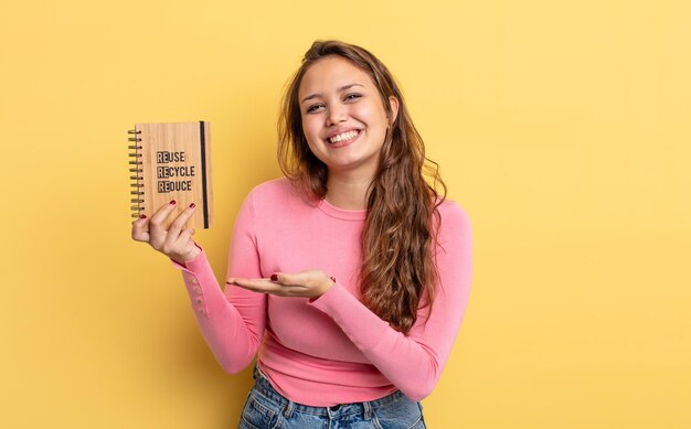 Mulher bonita hispânica sorrindo alegremente, sentindo-se feliz e mostrando um conceito. conceito de reciclagem