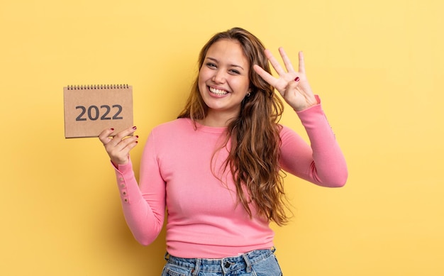 Mulher bonita hispânica sorrindo e parecendo amigável, mostrando o número quatro. conceito de calendário