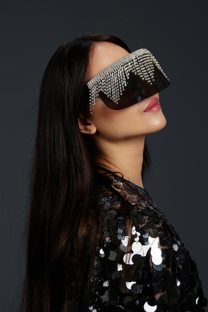 Foto mulher bonita jaqueta brilhante óculos de sol de moda posando luxo fundo isolado foto de alta qualidade