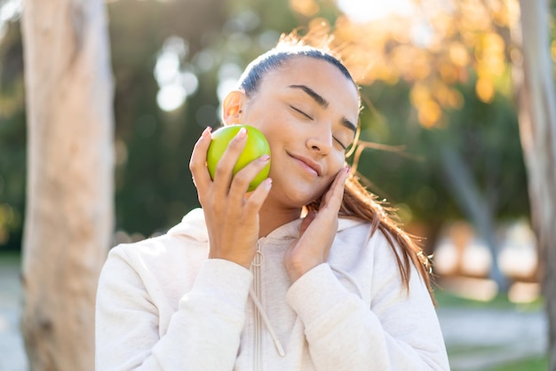 Mulher bonita jovem esporte segurando uma maçã com expressão feliz
