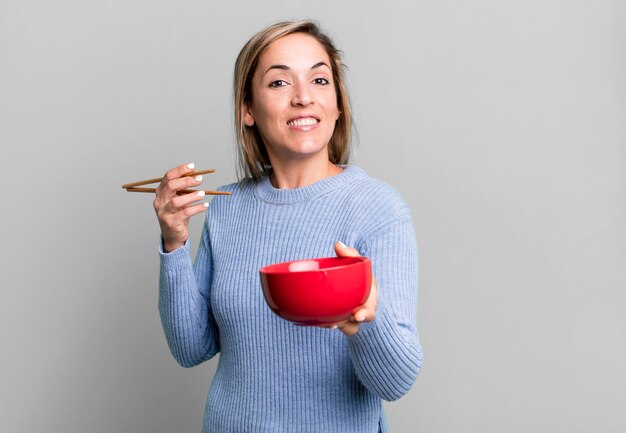 Foto mulher bonita loira com um conceito de treinador esportivo de ramen bowl com uma bola de futebol