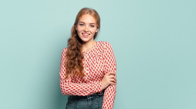 Mulher bonita loira rindo tímida e alegre, com uma atitude amigável e positiva, mas insegura