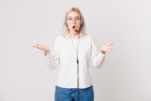 Mulher bonita loira se sentindo extremamente chocada e surpresa com o conceito de telemarketing