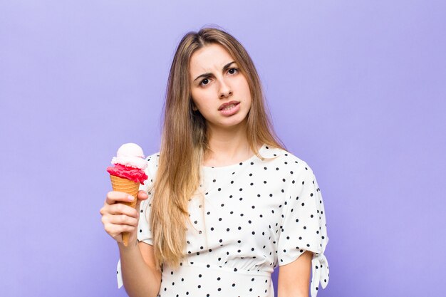 Mulher bonita loira sentindo-se perplexa e confusa, com uma expressão muda e atordoada olhando para algo inesperado