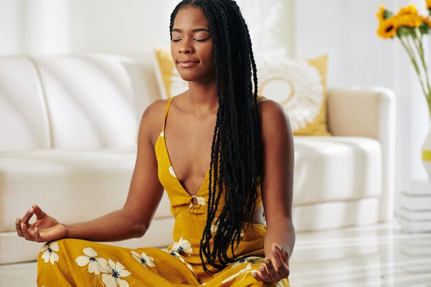 Mulher bonita meditando em casa