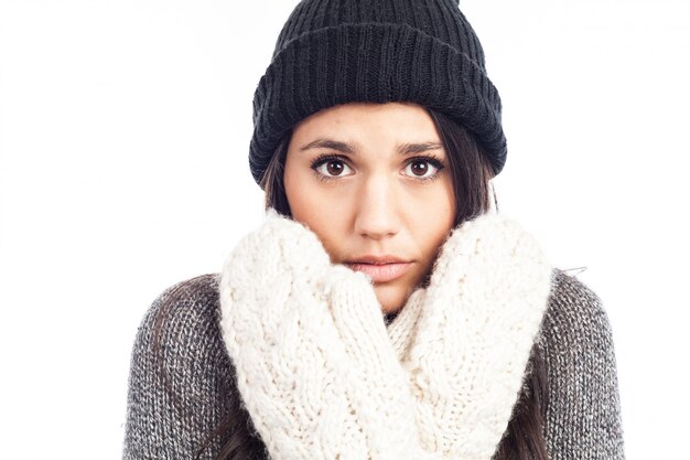 Mulher bonita morena com um chapéu de lã uma camisola e luvas que tem frio