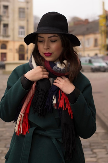 Mulher bonita morena de chapéu e casaco na rua em lviv