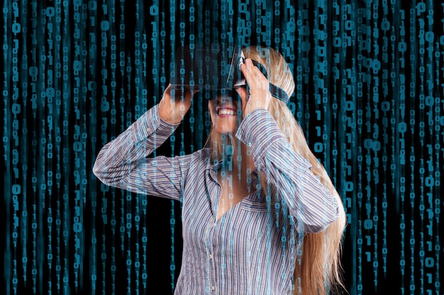 Foto mulher bonita na camisa cinza tocando algo curiosamente usando o fone de ouvido de realidade virtual