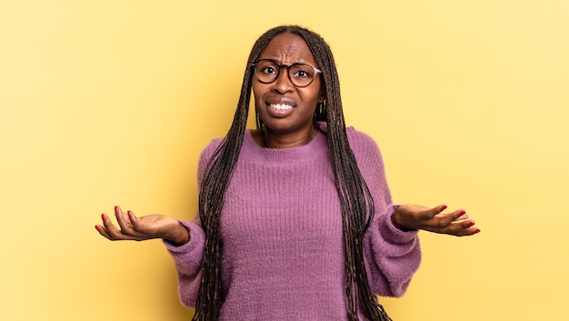 Mulher bonita negra afro se sentindo sem noção e confusa, sem saber qual escolha ou opção escolher, se perguntando