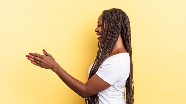 Mulher bonita negra afro sorrindo, cumprimentando você e oferecendo um aperto de mão para fechar um negócio de sucesso, conceito de cooperação