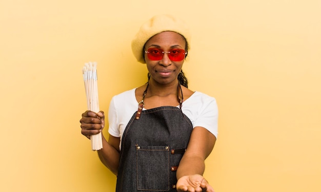 Mulher bonita negra sorrindo alegremente com amigável e oferecendo e mostrando um conceito