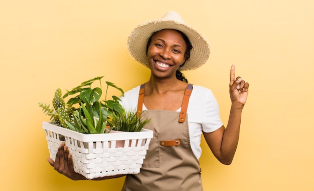 Mulher bonita negra sorrindo e parecendo amigável mostrando o número um