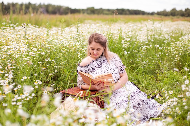 Mulher bonita no campo com flores. Foto de alta qualidade