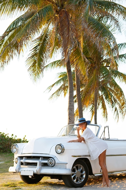 Mulher bonita no chapéu azul e branco retrô cabriolet