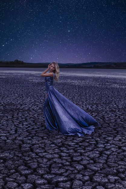 Mulher bonita no lago seco à noite