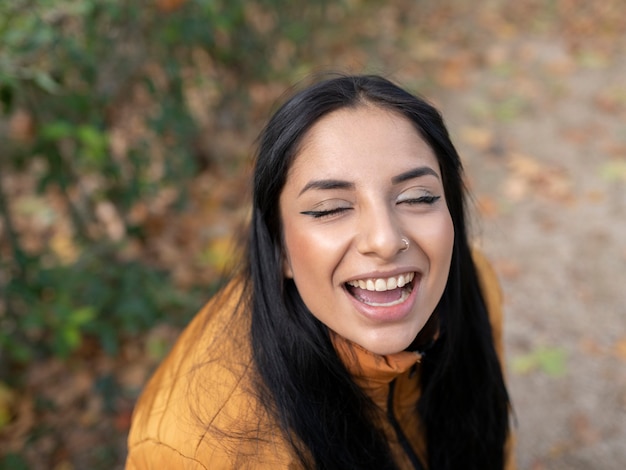 Mulher bonita no parque com os olhos fechados feliz