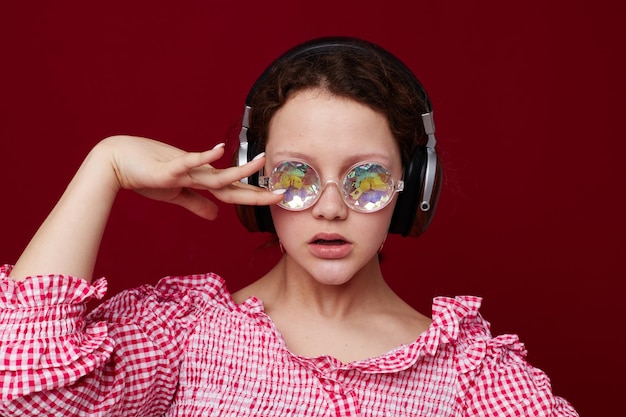 Mulher bonita óculos de diamante fones de ouvido música fundo vermelho inalterado