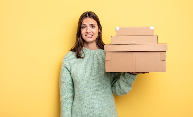 Mulher bonita olhando o conceito de caixas de pacotes confusos e confusos