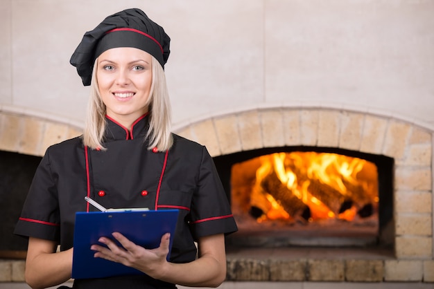 Mulher bonita, padeiro chef de uniforme preto.