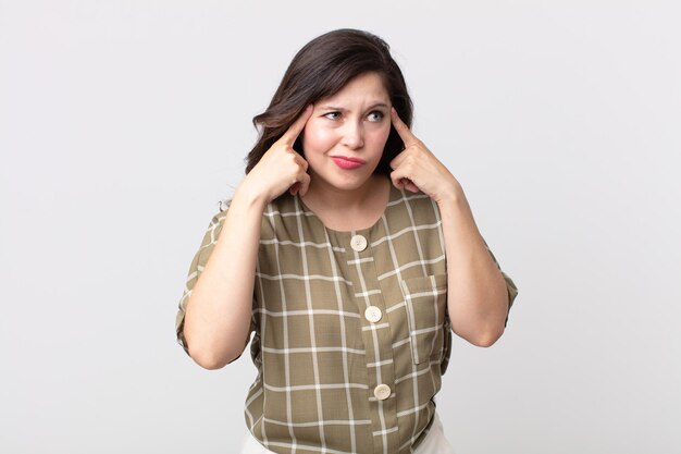 Mulher bonita parecendo concentrada e pensando seriamente em uma ideia, imaginando uma solução para um desafio ou problema