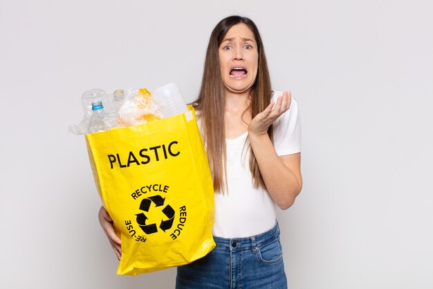 Foto mulher bonita parecendo desesperada e frustrada, estressada, infeliz e irritada, gritando e gritando