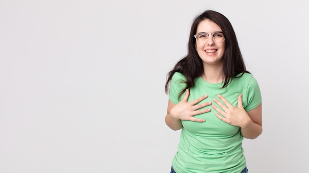 Mulher bonita parecendo feliz, surpresa, orgulhosa e animada, apontando para si mesma