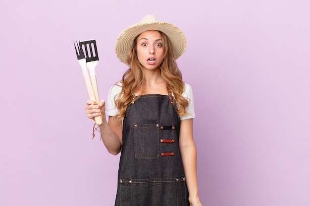 Mulher bonita parecendo muito chocada ou surpresa. conceito de chef de churrasco