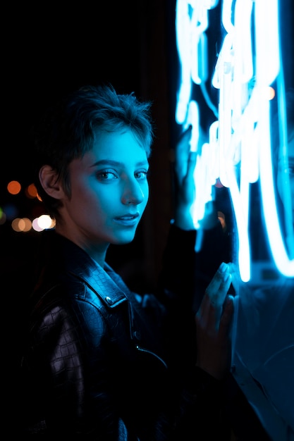 Mulher bonita posando à noite com luz de néon azul