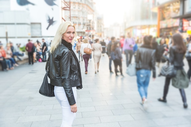 Mulher bonita que anda na rua aglomerada de Londres.